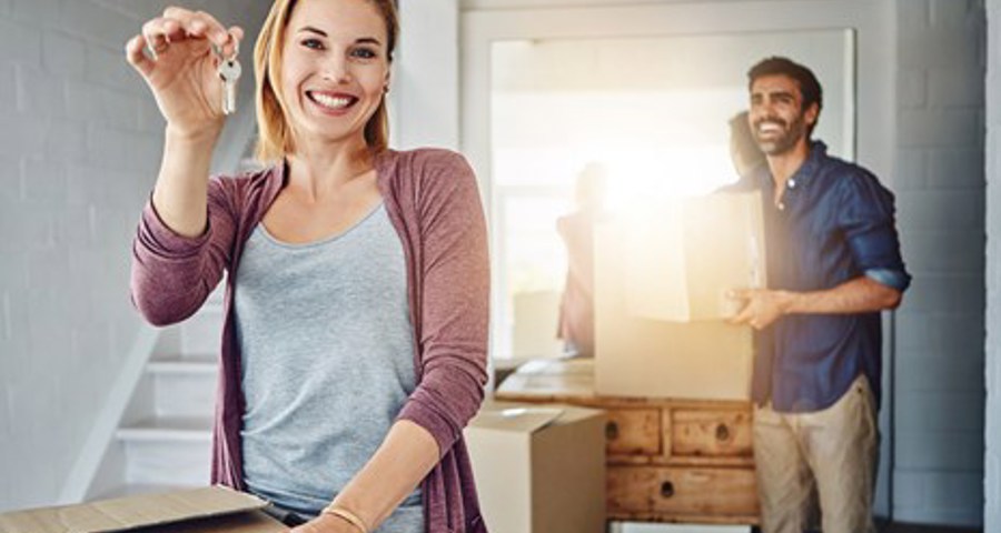 Happy couple holding a key in a hand